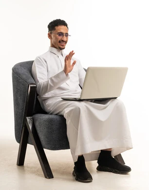 Saudi Man in Traditional Thobe Using Laptop Video Call