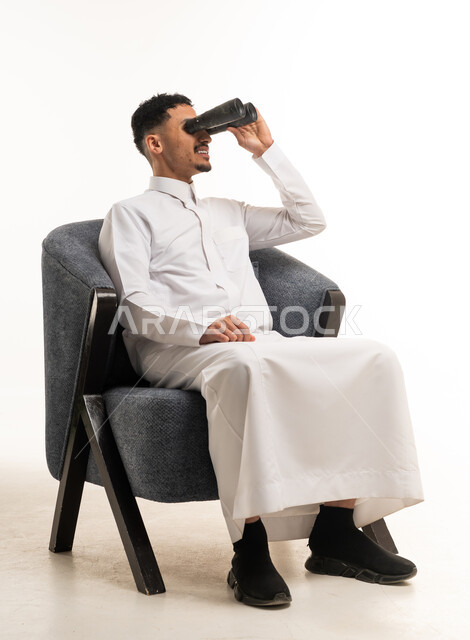 Saudi Man in Thobe Using Binoculars in Studio