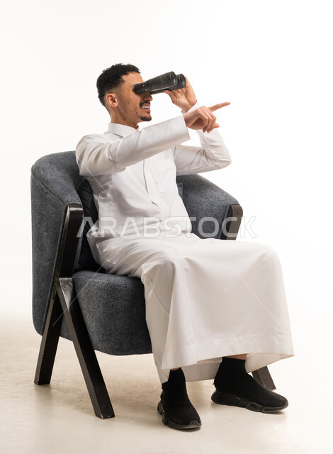 Saudi Man in Thobe Using Binoculars in Studio