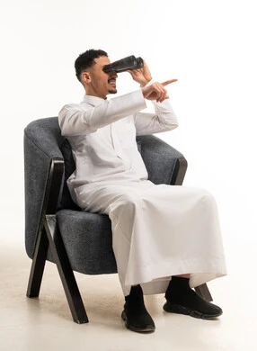Saudi Man in Thobe Using Binoculars in Studio