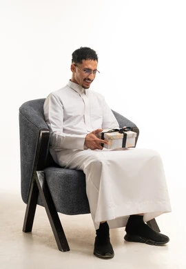 Saudi Man in White Thobe Holding Gift Box on White Background