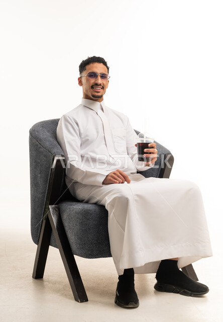 Saudi Man in Traditional Thobe Sitting with Cold Drink