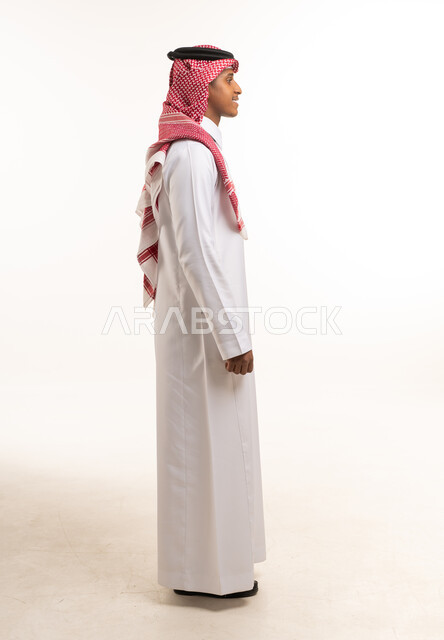رجل سعودي بالزي التقليدي بوضعية جانبية في استوديو