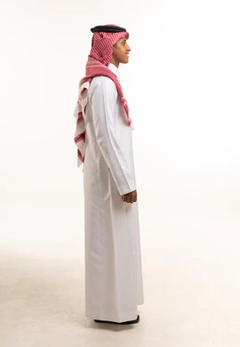 رجل سعودي بالزي التقليدي بوضعية جانبية في استوديو