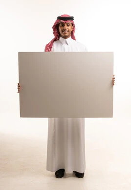 Saudi Man in Traditional Dress Holding Blank White Board