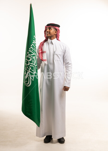 رجل سعودي يحمل علم المملكة العربية السعودية