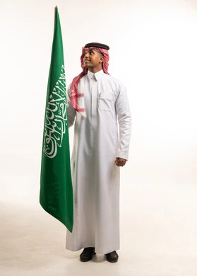 رجل سعودي يحمل علم المملكة العربية السعودية