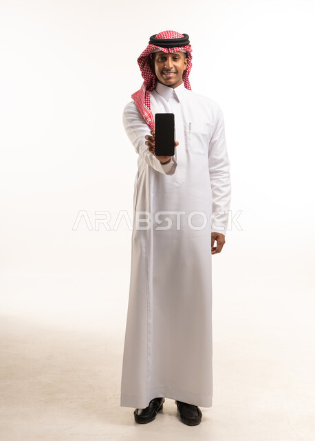 رجل سعودي يمسك هاتف ذكي بشاشة فارغة