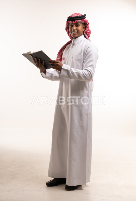 Saudi Man in Traditional Dress Holding a Book in Studio