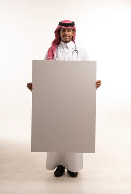 طبيب سعودي يحمل لوحة بيضاء فارغة في الاستوديو