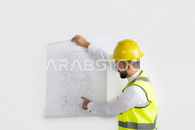 Portrait, Saudi Arabian engineer, skilled engineer in blueprints, Gulf man engineer, white background