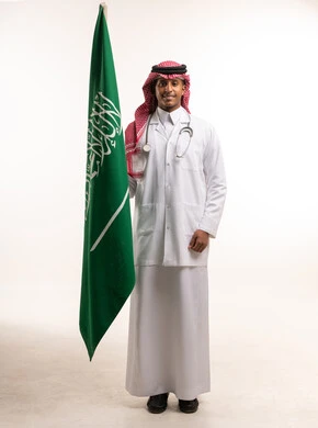 طبيب سعودي يحمل علم المملكة العربية السعودية