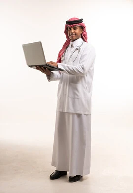 طبيب سعودي يحمل كمبيوتر محمول على خلفية بيضاء