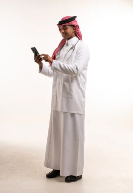 Saudi Male Doctor in Lab Coat Using Smartphone Studio Shot