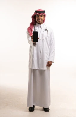 طبيب سعودي يمسك هاتفاً ذكياً في الاستوديو
