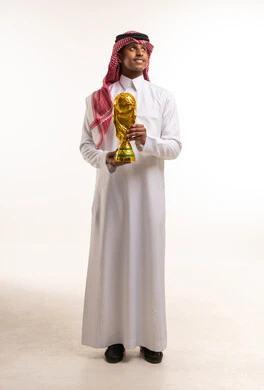 رجل سعودي يحمل مجسم كأس العالم الذهبي في الاستوديو