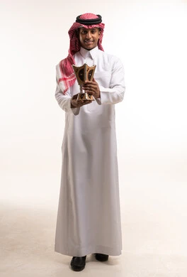 رجل سعودي بالزي التقليدي يمسك مبخرة بخور