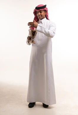 رجل سعودي بالزي التقليدي يحمل مبخرة بخور