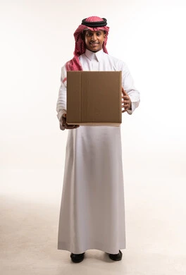 رجل سعودي يحمل صندوق شحن كرتوني في الاستوديو