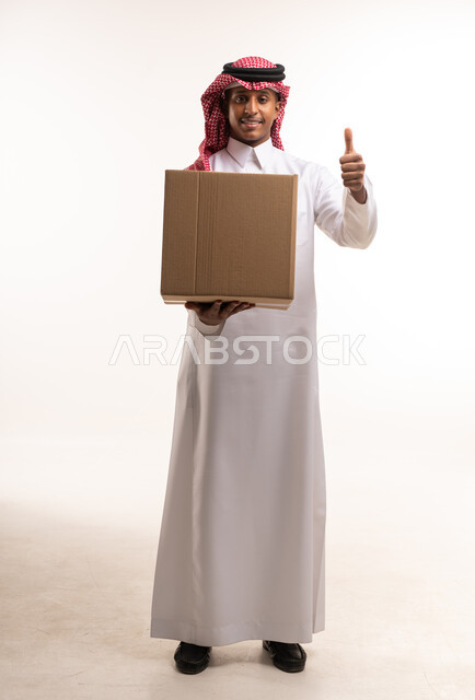 رجل سعودي يحمل صندوق شحن مع إيماءة النجاح