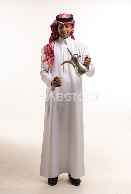رجل سعودي يصب القهوة العربية بالدلة الفضية