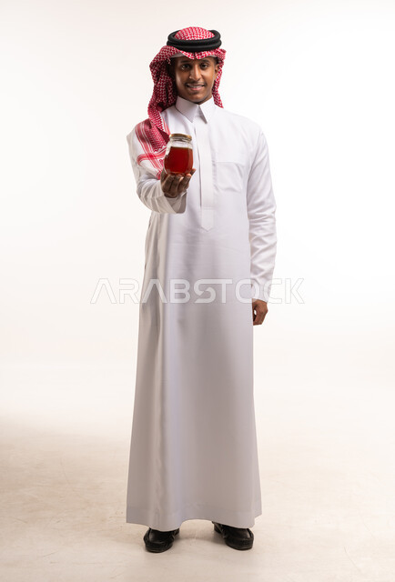 Saudi Man in Traditional Thobe Holding Honey Jar