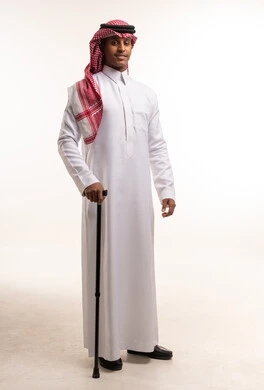 رجل سعودي بالزي التقليدي يحمل عصا مشي سوداء