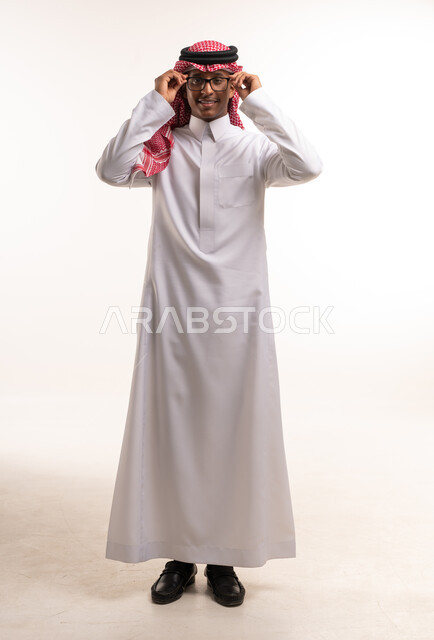 Saudi Man in Traditional Thobe Adjusting Glasses