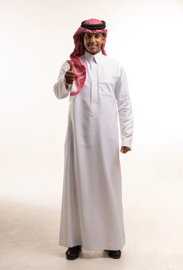 رجل سعودي بالزي التقليدي يرفع إبهامه للموافقة