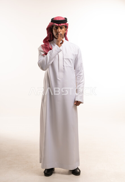 رجل سعودي بالثوب يطلب الصمت في استوديو