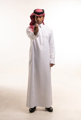 رجل سعودي بالثوب التقليدي والشماغ يقوم بإيماءة يد