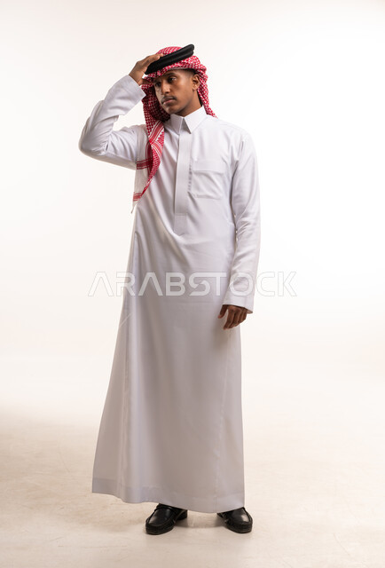 رجل سعودي يرتدي الثوب الأبيض والشماغ الأحمر في استوديو