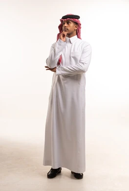 رجل سعودي بالزي التقليدي في وضعية تفكير بداخل استوديو