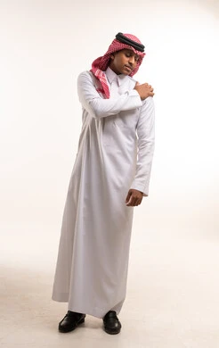 شاب سعودي بالزي التقليدي يعاني من ألم الكتف