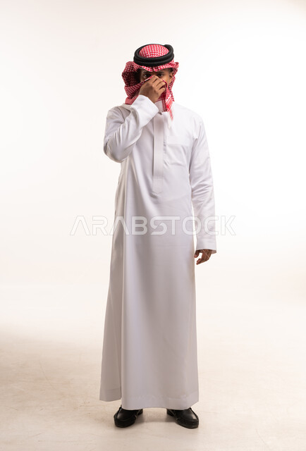 رجل سعودي بالثوب الأبيض والشماغ الأحمر في الاستوديو