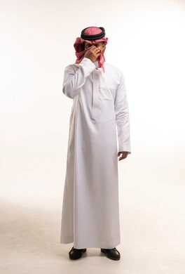 رجل سعودي بالثوب الأبيض والشماغ الأحمر في الاستوديو