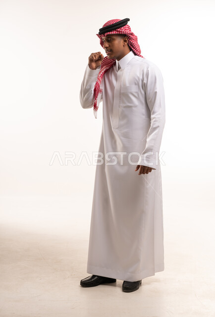 رجل سعودي يرتدي الثوب التقليدي يسعل في استوديو