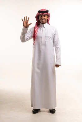 رجل سعودي يرتدي الثوب التقليدي يشير برقم خمسة بيده