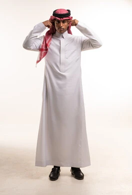 رجل سعودي يرتدي الثوب والشماغ على خلفية بيضاء سادة
