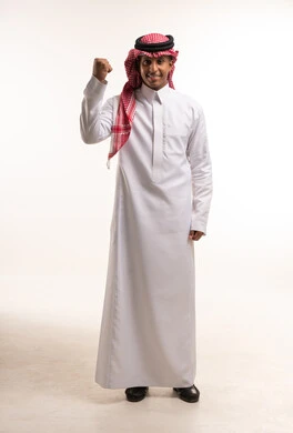 رجل سعودي بالثوب التقليدي يرفع قبضة النجاح والنصر