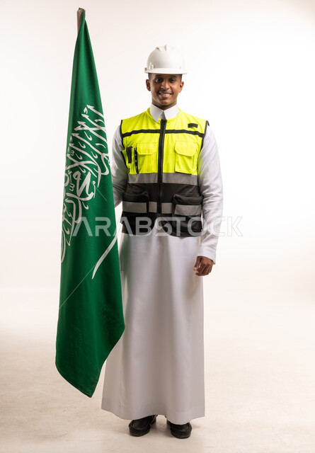 مهندس سعودي مع العلم الوطني ومعدات السلامة