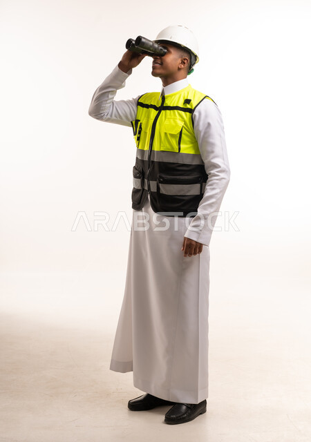 مهندس سعودي بالثوب التقليدي ينظر عبر المنظار