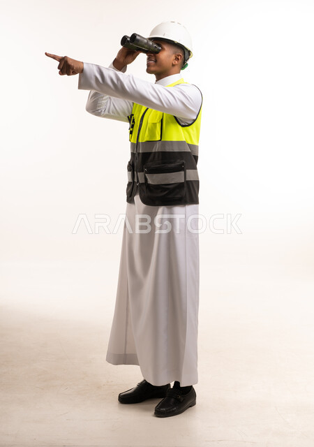 مهندس سعودي يستخدم المنظار ويرتدي خوذة السلامة
