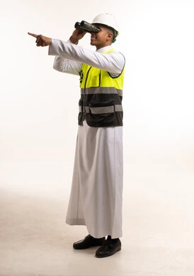 مهندس سعودي يستخدم المنظار ويرتدي خوذة السلامة