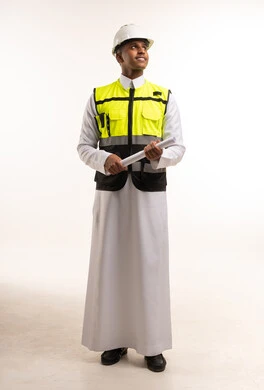 مهندس سعودي بالثوب التقليدي يحمل مخططاً هندسياً