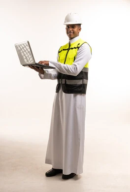 مهندس سعودي بالثوب التقليدي ومعدات السلامة مع لابتوب