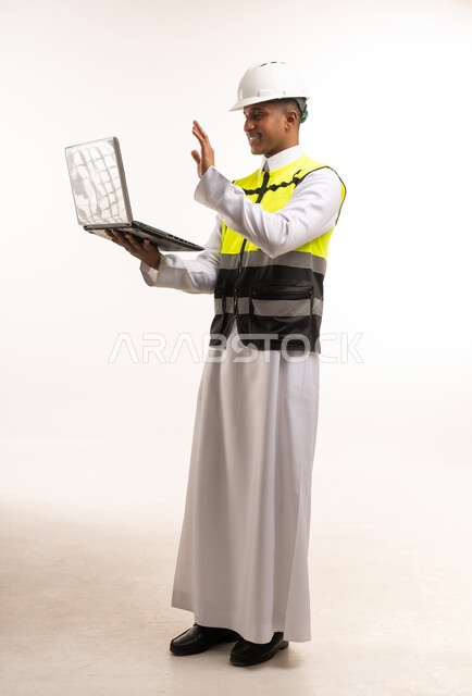 مهندس سعودي مع حاسوب محمول ومعدات السلامة