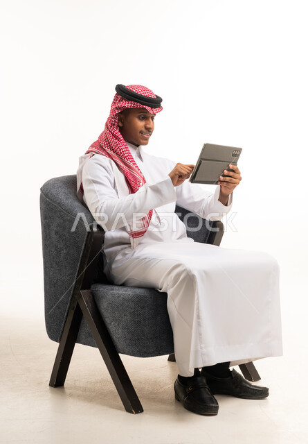 Saudi Man in Traditional Thobe Using Digital Tablet