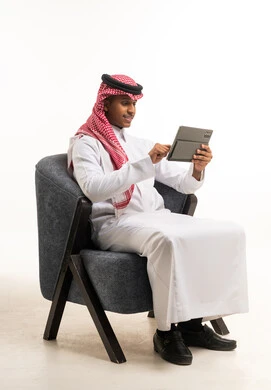 Saudi Man in Traditional Thobe Using Digital Tablet