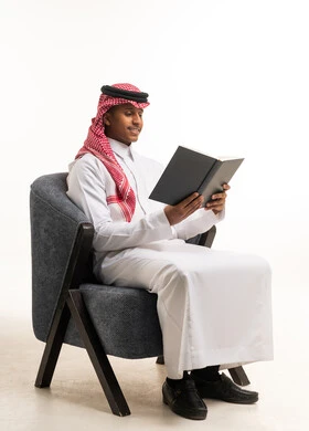 Saudi Man Reading Book in Traditional Thobe and Shemagh